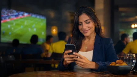Pessoa acompanhando futebol e notícias esportivas pelo celular